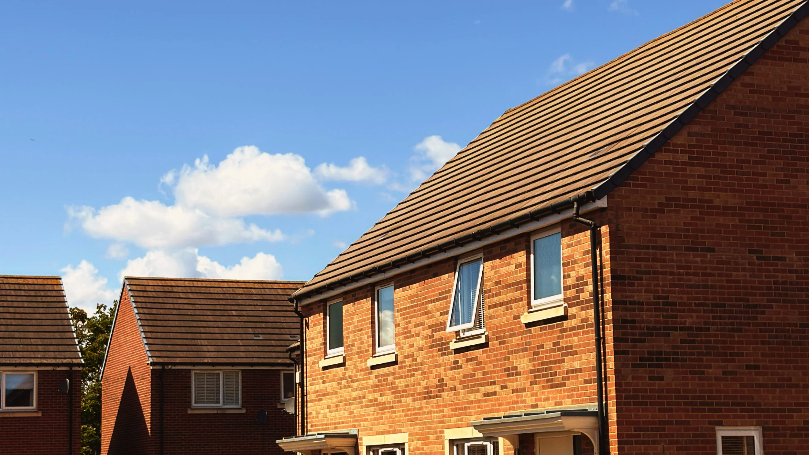 Modern red-brick homes in Killingworth under a blue sky